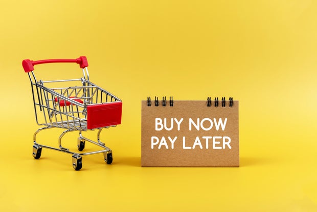 Buy Now Pay Later Sign connected Yellow Background