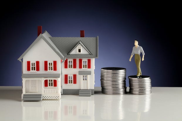 Model house and stack of coins-Concept of money saving 
