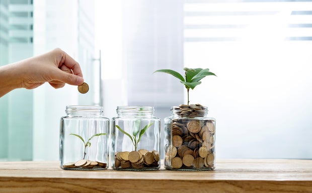 Woman putting coin successful the jar with works