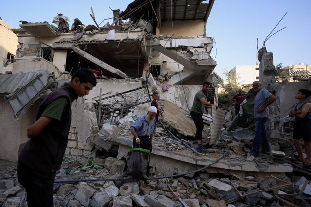 Palestinians inspect the site of an overnight Israeli strike on a house, in Gaza City 