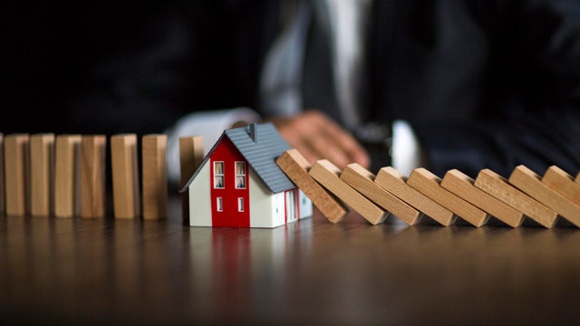Businessman hand protect home, insurance concept 