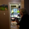 Barbara Quart looks at one of her paintings hanging in a home 