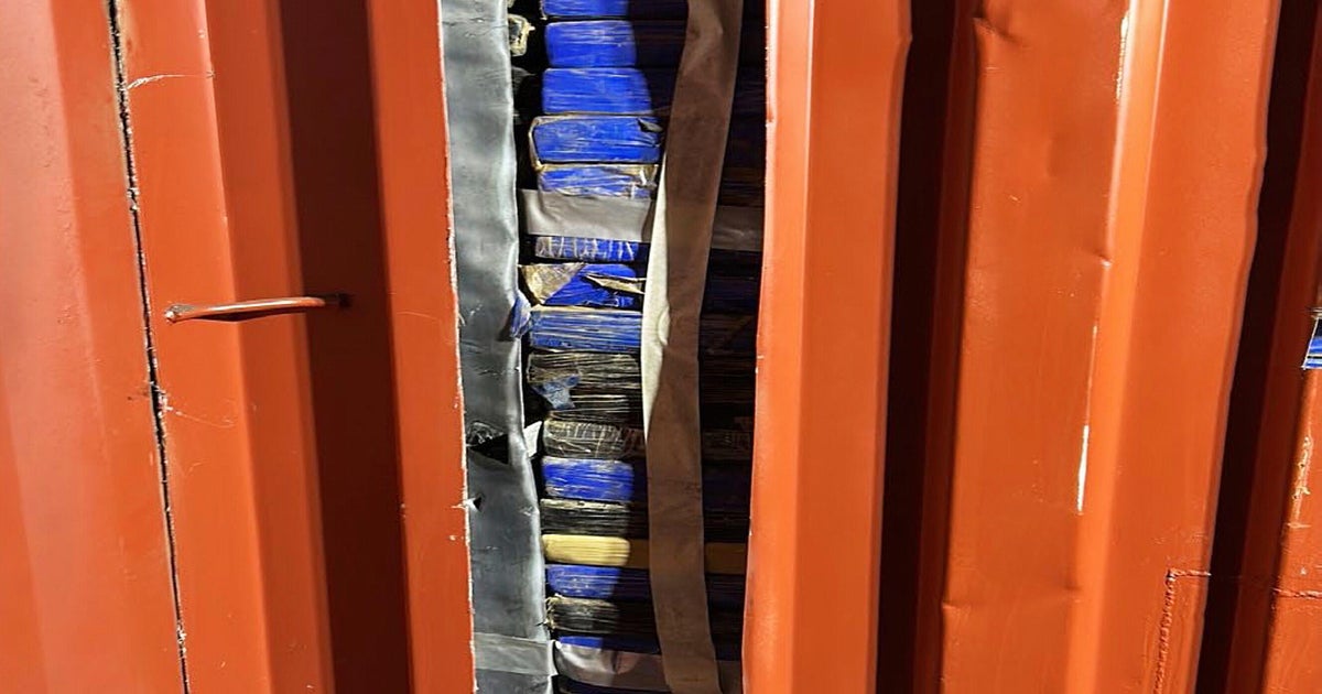 Dockworkers arrested after 1,116 kilos of cocaine discovered hidden behind faux wall in delivery container in Sydney