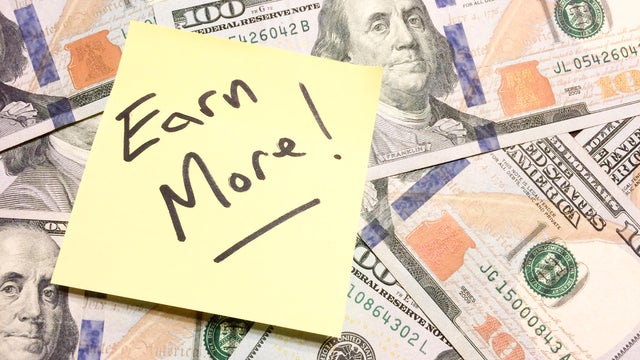 American cash money and yellow post it note with text Earn More 