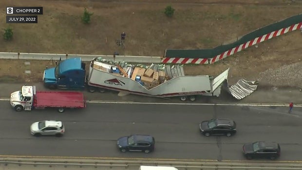 An aerial view of a tractor trailer with a sheared-off roof. 