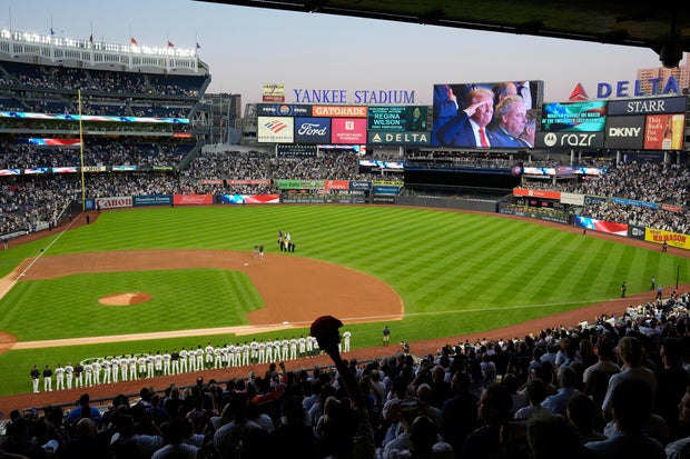 President Donald Trump appears on a screen during the National Anthem as he attends a Detroit Tigers against the New York Yankees baseball game, Thursday, Sept. 11, 2025, in New York. 
