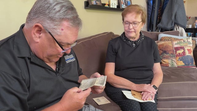 Kathleen Morris Rosati and John Morris look at the letters while sitting on the couch at a home 