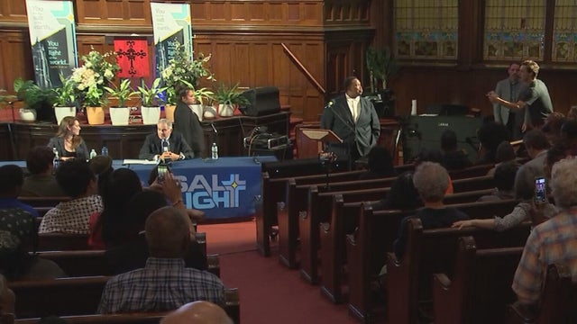 Larry Krasner and an attendee speak at a town hall at a Philadelphia church 