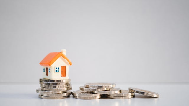 Miniature colorful house on stack coins 