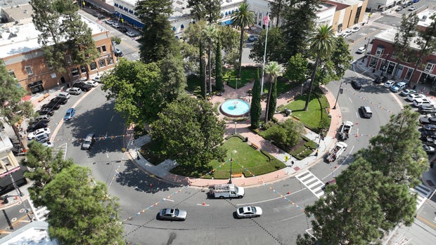 An aerial view of workers and people walking through Old Towne Orange Plaza Park near the historic fountain at the center of the circle in Old Towne Orange that was damaged again when a suspected DUI driver plowed into the plaza.