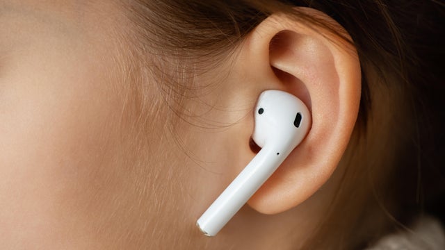 Wireless earphone in the girl's ear. 