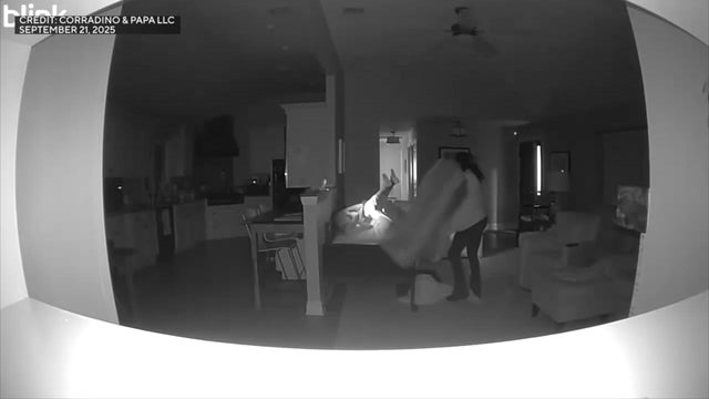 85-year-old woman laying in bed clutching her head as home health care aide stands over her 