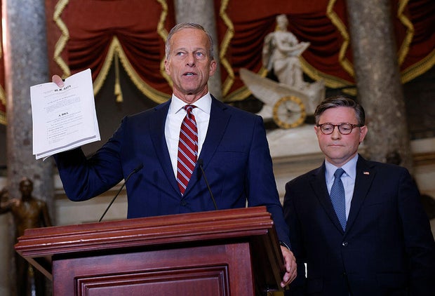 Senate Majority Leader John Thune of South Dakota holds a copy of a continuing resolution as he speaks alongside House Speaker Mike Johnson of Louisiana in Statuary Hall at the U.S. Capitol in Washington, D.C., on Oct. 3, 2025. 