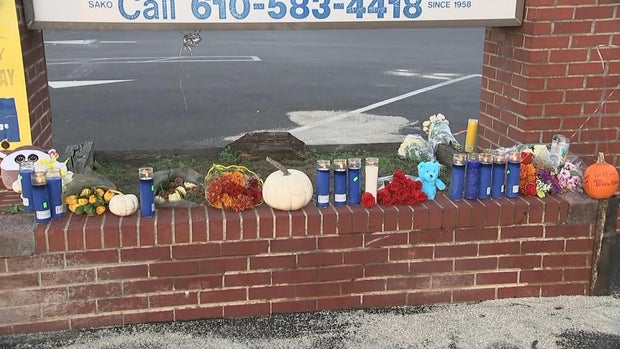 Candles, flowers and pumpkins are seen at a makeshift memorial for the two victims of a fatal motorcycle crash 