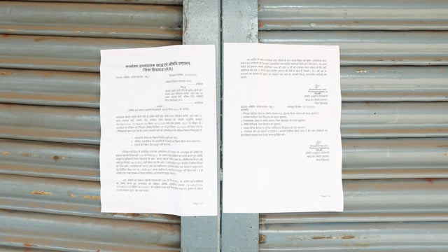 A notice by local drug administration is displayed on the sealed medical clinic of a doctor accused of prescribing cough syrup linked to the deaths of multiple children, in Parasia 