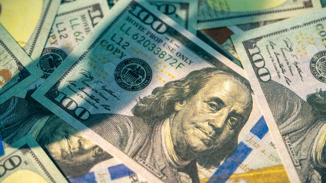 Close-up of benjamin franklin on scattered one hundred dollar bills 