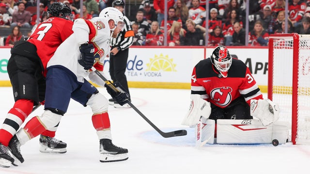 New Jersey Devils goaltender Jake Allen (34) makes a save on Florida Panthers center Sam Bennett (9) during a game between the Florida Panthers and New Jersey Devils at Prudential Center on October 16, 2025 in Newark, New Jersey. 