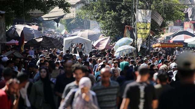 Palestinians gather at a market in Deir el-Balah in the central Gaza Strip 