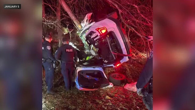 A police vehicle on its side crashed into a tree 
