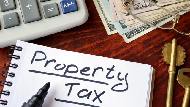 Property tax written in a notebook and calculator.