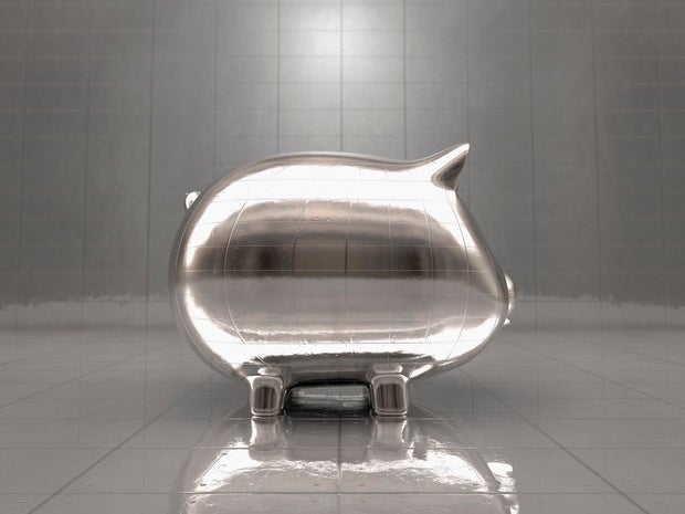 Metal piggy bank reflecting office walls