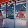 A sign reading "We Accept Food Stamps" hangs in the window of a grocery store in Miami on Oct. 31, 2025. 