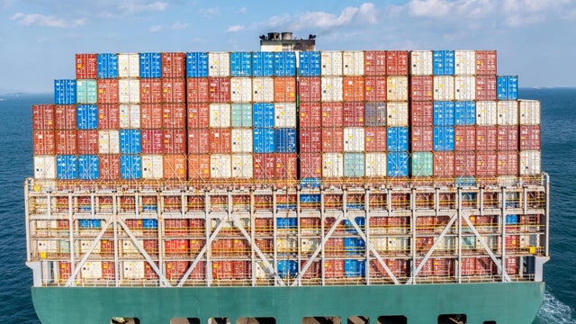Close-up: Rear view of an freighter full of containers is sailing at sea 