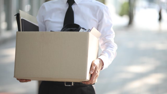 Close-up Of Unemployed Businessperson Carrying Cardboard Box 