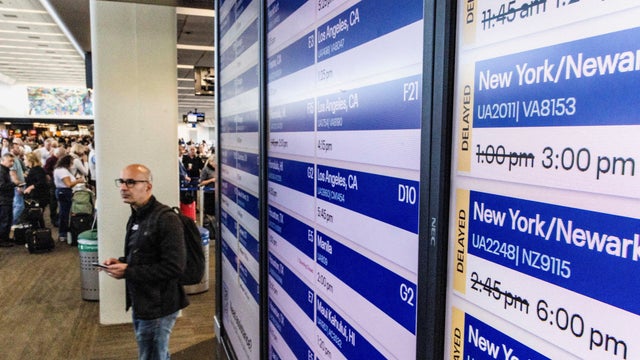A passenger stands by a screen showing delayed flights due to the government shutdown, at San Francisco International Airport in San Francisco, California, Nov. 6, 2025. 