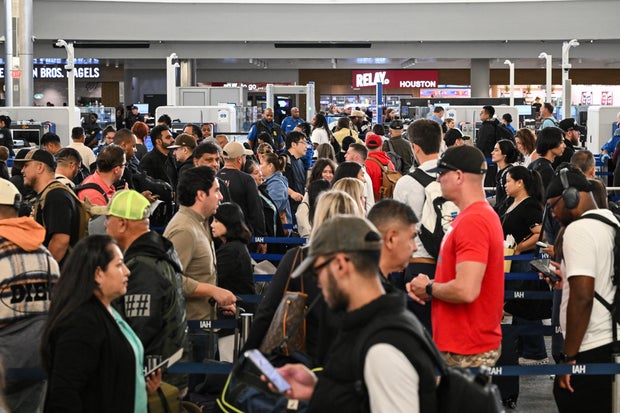 Travelers wait in line at a security checkpoint at George Bush Intercontinental Airport in Houston, Texas, Nov. 7, 2025.