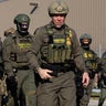 U.S. Border Patrol Chief Gregory Bovino, center, leads federal agents toward protesters near the U.S. Immigration and Customs Enforcement holding facility in Broadview, Illinois, on Oct. 3, 2025. 