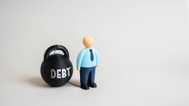 An office worker and the weight of debt. The debt trap prevents one from escaping poverty. 