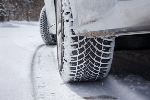 Car winter tires leaving a track in the snow , stock photo