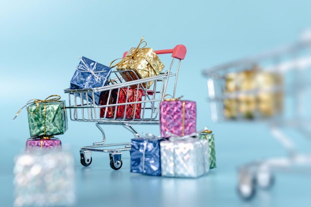 Black Friday Sale and Online Shopping Concepts, Mini Shopping Cart Carrying With Multi Colored Gift Box on Blue Isolated Background. 