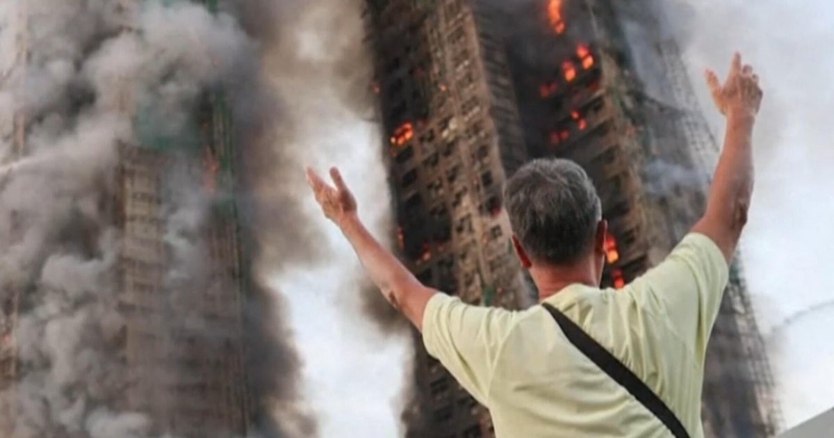 Distraught family members await answers as Hong Kong fire rages on and death toll climbs