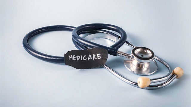 Stethoscope Near Piece of Paper with Medicare Text on Blue Background: A Concept for US Government Health Insurance and Senior Healthcare 
