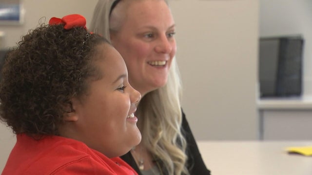 Lianna and her mom speak to a reporter in a conference room 