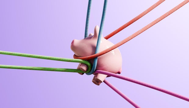 Financial Strain: Piggybank Pulled in Different Directions by Colorful Ropes 
