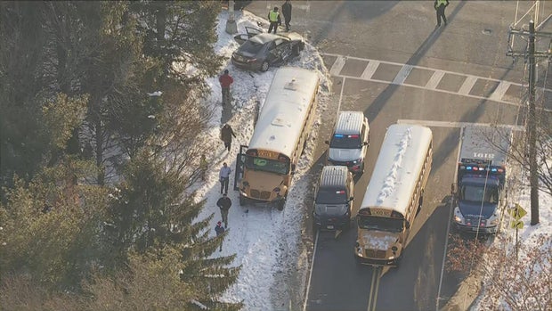 Helicopter shot of two school buses, a damaged car and multiple police cars after the crash