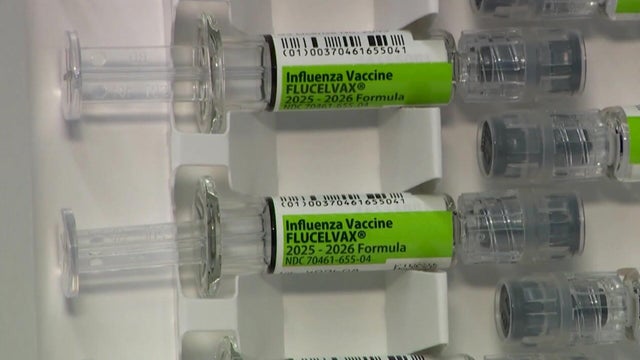 A health care worker prepares a vaccine. 
