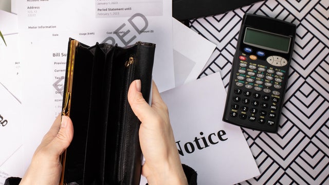 Empty Wallet with Utility Bill and Calculator: Financial Crisis Concept 