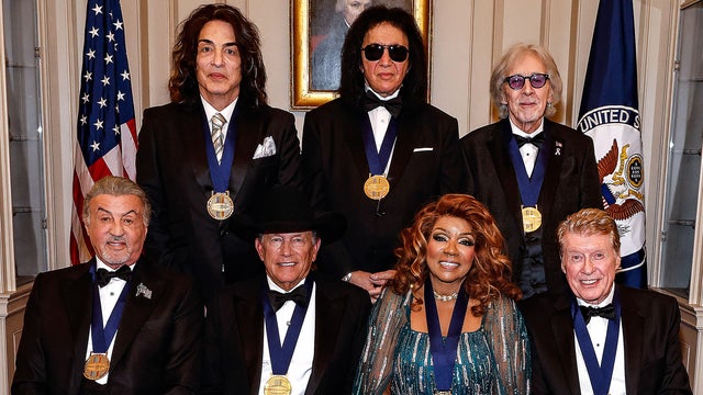 Back row from left to right, Paul Stanley, Gene Simmons and Peter Criss of Kiss and, front row from left to right, Sylvester Stallone, George Strait, Gloria Gaynor and Michael Crawford pose for the class photo at the Kennedy Center Honors medallion reception at the State Department on Dec. 6, 2025 in Washington. 