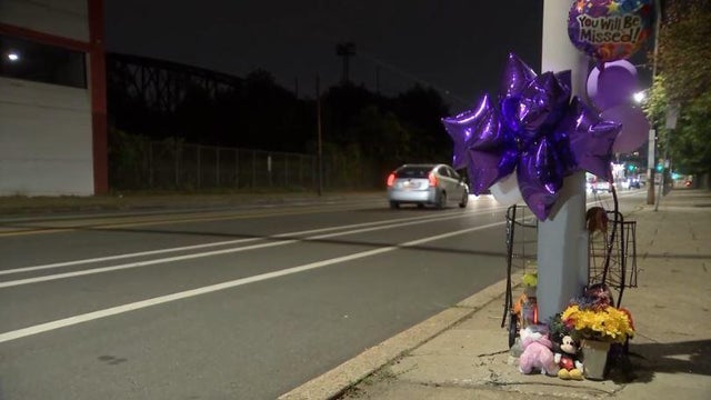 A memorial on Lancaster Avenue in Overbrook contains balloons and flowers 