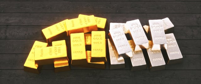 A stack of gold and silver ingots on a wooden floor 