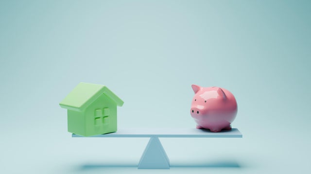 Balance between budget and house  with piggy bank 