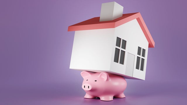 Flattened pink piggy bank carry a toy house on its back on a purple background. Illustration of the concept of the burden of mortgage loans and heavy debt 