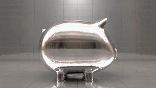 Metal piggy bank reflecting office walls 