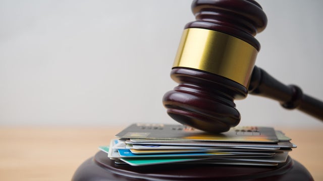 Close up judge hammer gavel on many credit card with white wall background copy space. 