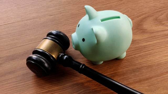 Gavel and Piggy Bank on Wooden Table 