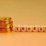 invest word with gold coins stack 